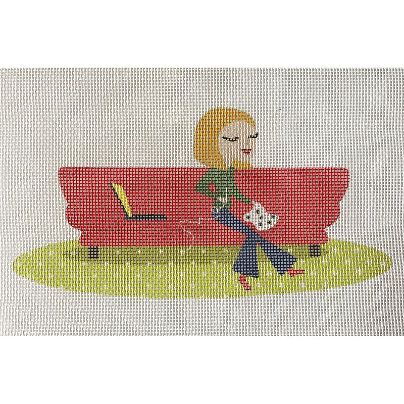 Needlepoint-for-fun stitcher on red sofa